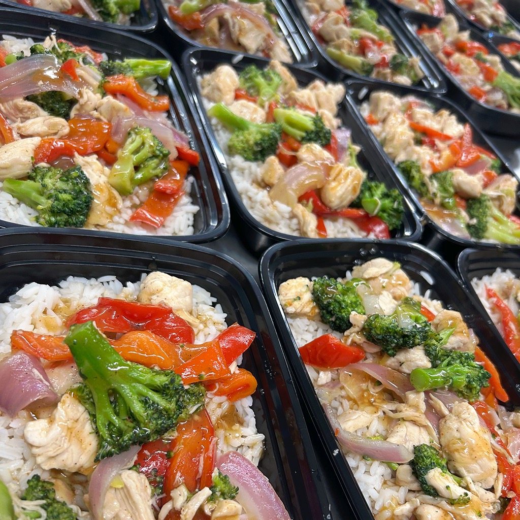 Prepared chicken and vegetable meals in black containers