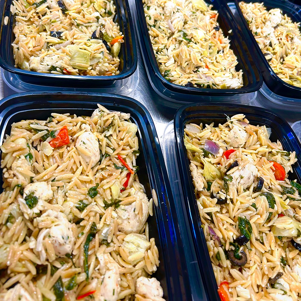 Prepared chicken and vegetable orzo meals in containers