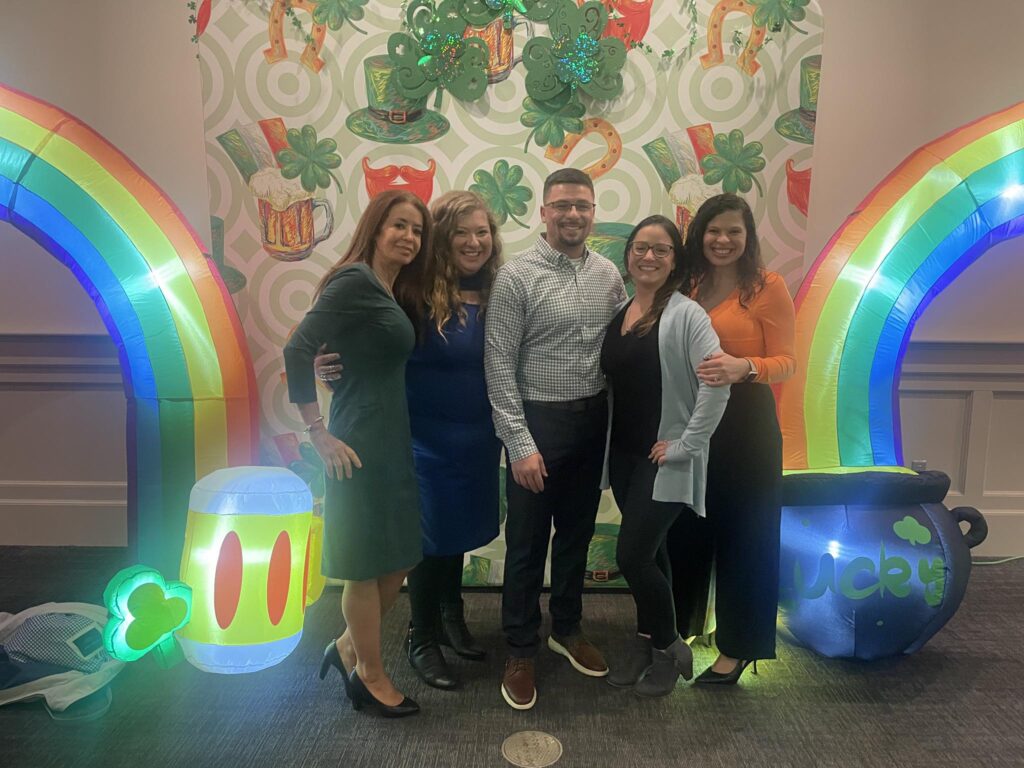 Group of five adults celebrating at St. Patrick's event