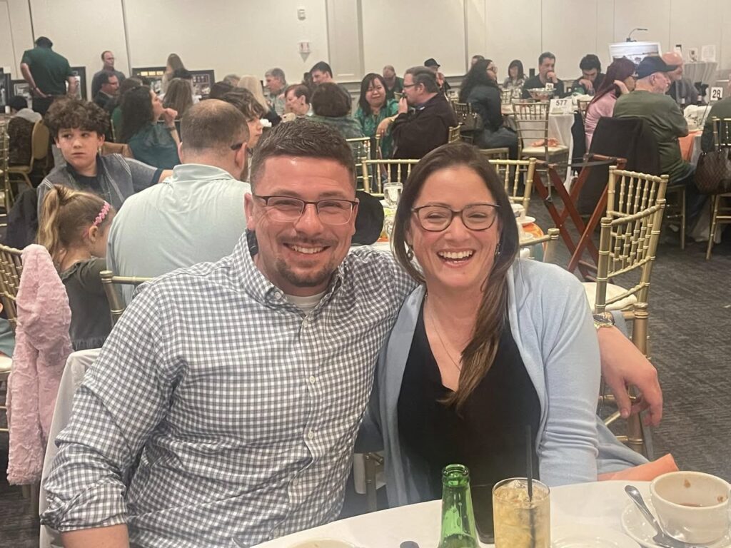 Laughing couple at crowded event dinner table