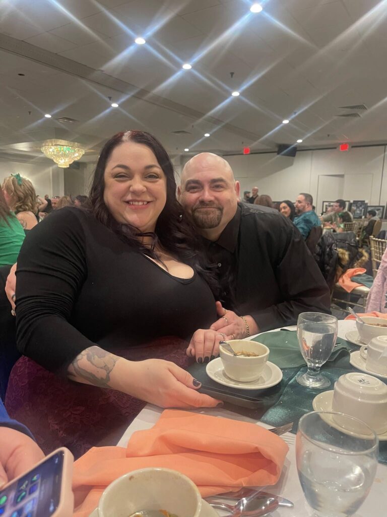 Couple smiling at dinner event with ambient lighting